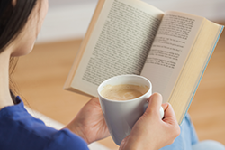 Women reading a book with a cup of coffee