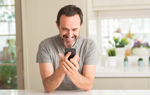 Happy man looking down at cell phone