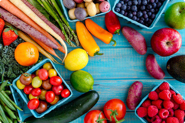 Fruits and vegetables sitting on blue wooden background