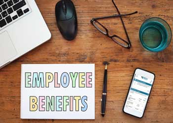 Desk with a sign saying employee wellness next to a phone and computer