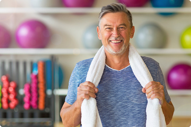 Man in a gym with a towel around his neck