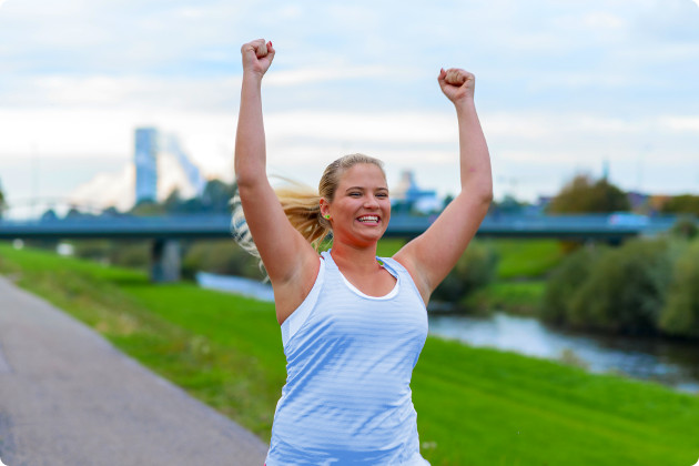 Excited women running outside near a bridge cheering