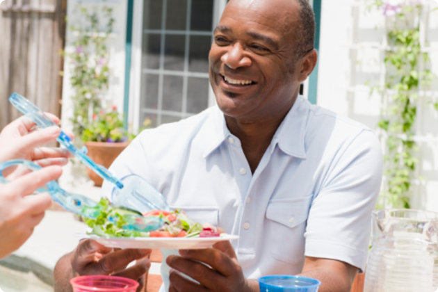 Man eating salad on a patio