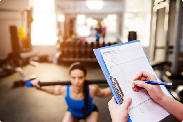 Girl working out with a health coach who has a clipboard