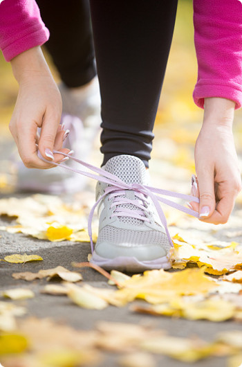 Tying shoes laces with an autumn background