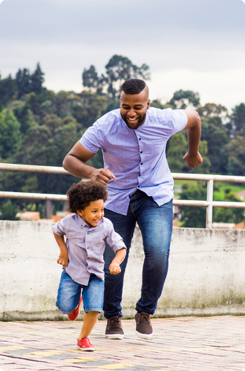 Man happily chasing his son