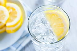 Glass of water with a plate of lemons