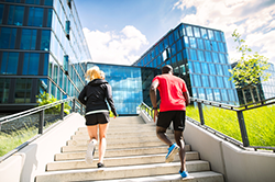 A man and women running up office steps