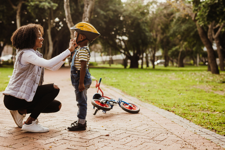 Women buckling her sons cycling helmet