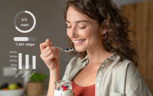 Women eating yogurt and tracking her eating habits, steps, and weight.